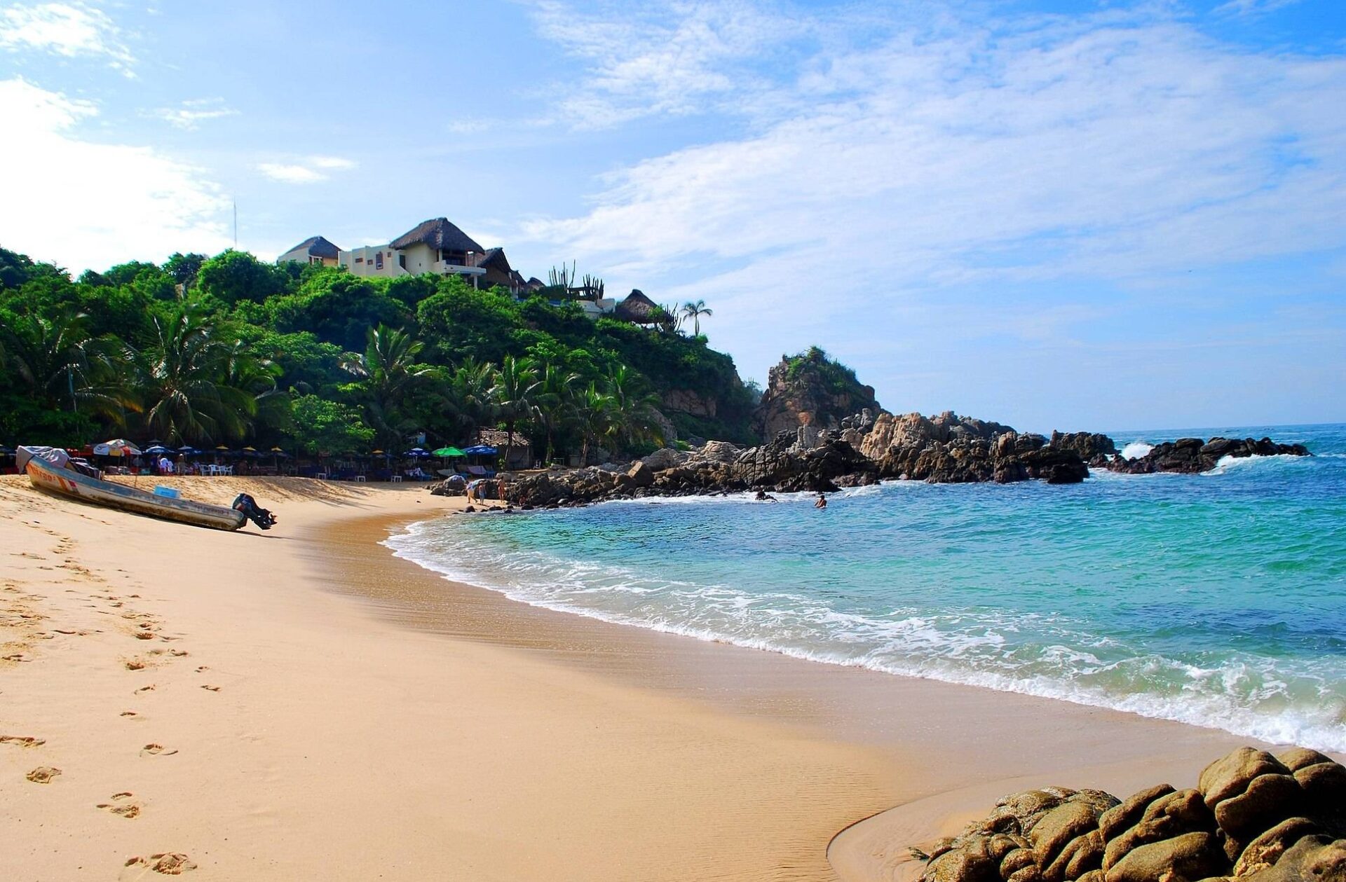 vista de día en playa manzanillo con arena y montaña con areas verdes en puerto escondido