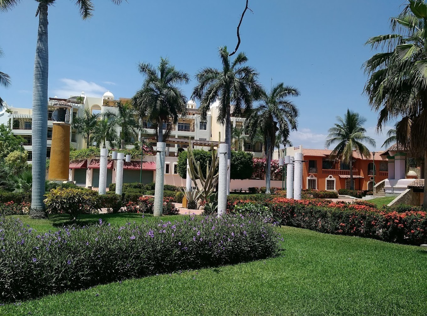 vista del exterior del hotel Bahia Huatulco con palmeras, áreas verdes y vista al cielo en Huatulco, Oaxaca 