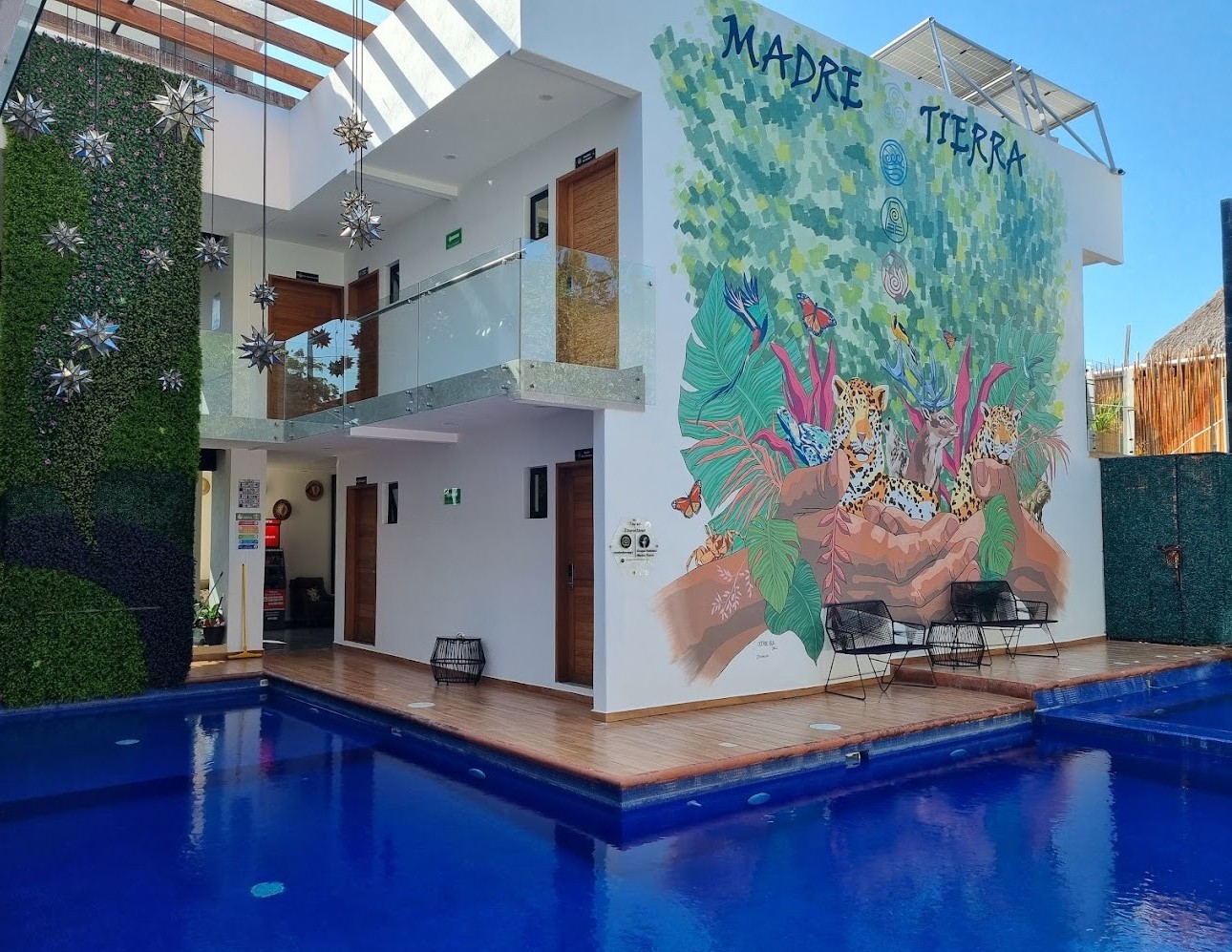 vista de hotel madre tierra en Mazunte Oaxaca con piscina, edificio y áreas verdes 