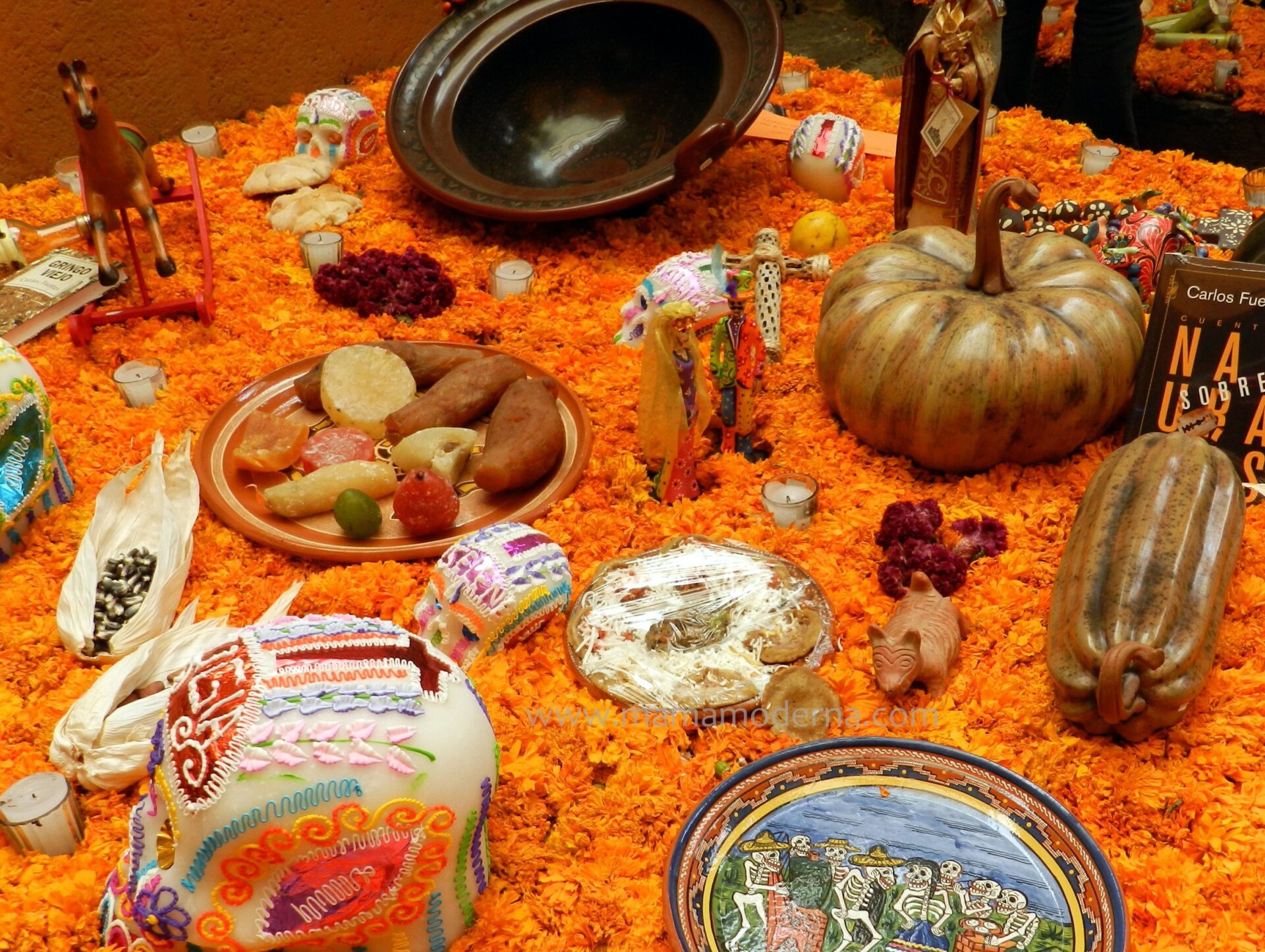 ofrenda flores de cempasúchil típicas de día de muertos con comida, calaveras y calabazas en Oaxaca